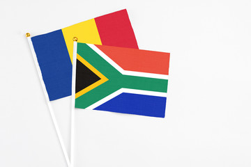 Fototapeta premium South Africa and Romania stick flags on white background. High quality fabric, miniature national flag. Peaceful global concept.White floor for copy space.