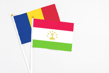 Tajikistan and Romania stick flags on white background. High quality fabric, miniature national flag. Peaceful global concept.White floor for copy space.