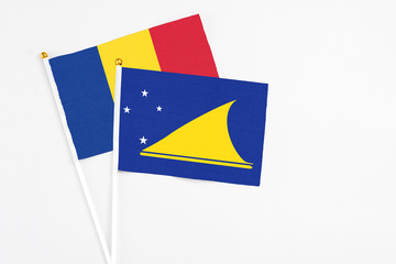 Tokelau and Romania stick flags on white background. High quality fabric, miniature national flag. Peaceful global concept.White floor for copy space.