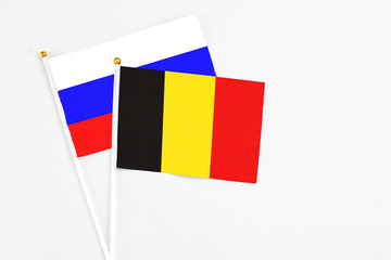 Belgium and Russia stick flags on white background. High quality fabric, miniature national flag. Peaceful global concept.White floor for copy space.
