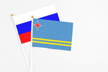 Aruba and Russia stick flags on white background. High quality fabric, miniature national flag. Peaceful global concept.White floor for copy space.
