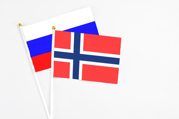 Bouvet Islands and Russia stick flags on white background. High quality fabric, miniature national flag. Peaceful global concept.White floor for copy space.