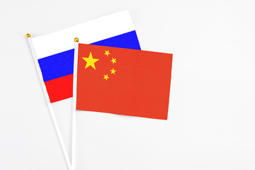 China and Russia stick flags on white background. High quality fabric, miniature national flag. Peaceful global concept.White floor for copy space.
