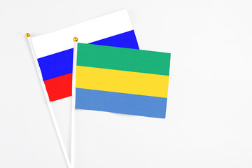 Gabon and Russia stick flags on white background. High quality fabric, miniature national flag. Peaceful global concept.White floor for copy space.