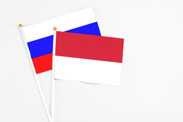 Indonesia and Russia stick flags on white background. High quality fabric, miniature national flag. Peaceful global concept.White floor for copy space.