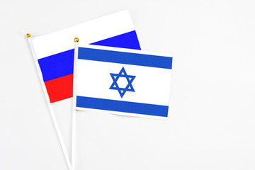 Israel and Russia stick flags on white background. High quality fabric, miniature national flag. Peaceful global concept.White floor for copy space.