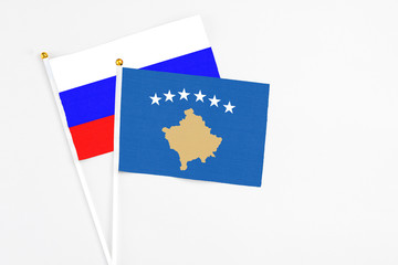 Kosovo and Russia stick flags on white background. High quality fabric, miniature national flag. Peaceful global concept.White floor for copy space.
