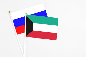 Kuwait and Russia stick flags on white background. High quality fabric, miniature national flag. Peaceful global concept.White floor for copy space.
