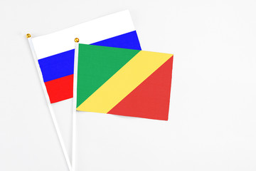 Republic Of The Congo and Russia stick flags on white background. High quality fabric, miniature national flag. Peaceful global concept.White floor for copy space.