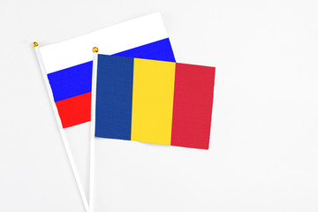 Romania and Russia stick flags on white background. High quality fabric, miniature national flag. Peaceful global concept.White floor for copy space.