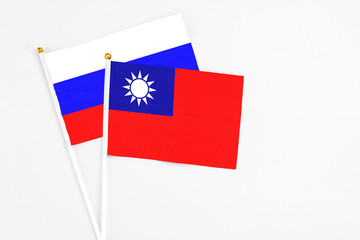 Taiwan and Russia stick flags on white background. High quality fabric, miniature national flag. Peaceful global concept.White floor for copy space.