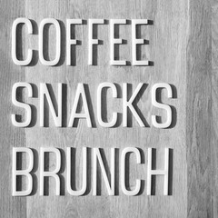 Brunch, snacks, coffee. embossed words on grey background. White volumetric letters making the words Coffee, Snacks, Brunch. Business lunch background. Coffee break concept. Sign for break time