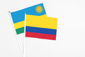 Colombia and Rwanda stick flags on white background. High quality fabric, miniature national flag. Peaceful global concept.White floor for copy space.
