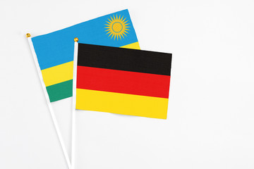 Germany and Rwanda stick flags on white background. High quality fabric, miniature national flag. Peaceful global concept.White floor for copy space.
