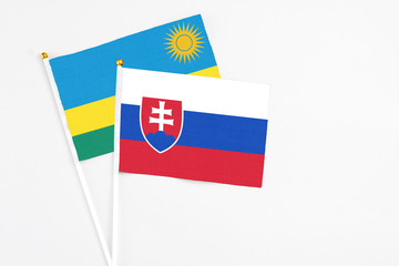 Slovakia and Rwanda stick flags on white background. High quality fabric, miniature national flag. Peaceful global concept.White floor for copy space.