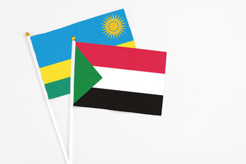 Sudan and Rwanda stick flags on white background. High quality fabric, miniature national flag. Peaceful global concept.White floor for copy space.