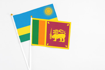 Sri Lanka and Rwanda stick flags on white background. High quality fabric, miniature national flag. Peaceful global concept.White floor for copy space.