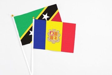 Andorra and Saint Kitts And Nevis stick flags on white background. High quality fabric, miniature national flag. Peaceful global concept.White floor for copy space.