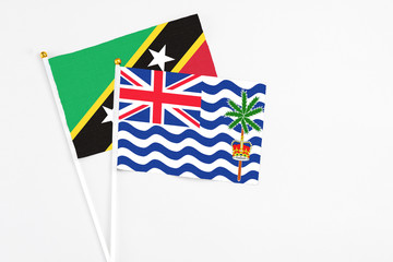 British Indian Ocean Territory and Saint Kitts And Nevis stick flags on white background. High quality fabric, miniature national flag. Peaceful global concept.White floor for copy space.