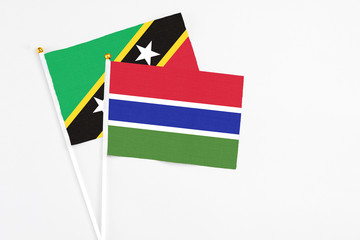 Gambia and Saint Kitts And Nevis stick flags on white background. High quality fabric, miniature national flag. Peaceful global concept.White floor for copy space.