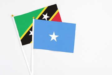 Somalia and Saint Kitts And Nevis stick flags on white background. High quality fabric, miniature national flag. Peaceful global concept.White floor for copy space.