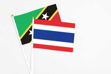 Thailand and Saint Kitts And Nevis stick flags on white background. High quality fabric, miniature national flag. Peaceful global concept.White floor for copy space.