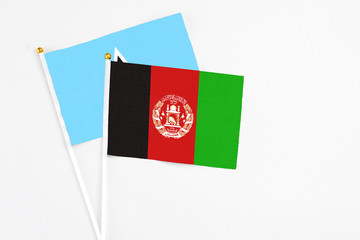 Afghanistan and Saint Lucia stick flags on white background. High quality fabric, miniature national flag. Peaceful global concept.White floor for copy space.