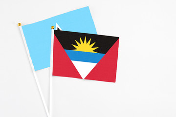 Antigua and Barbuda and Saint Lucia stick flags on white background. High quality fabric, miniature national flag. Peaceful global concept.White floor for copy space.