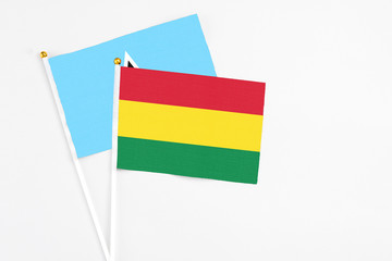 Bolivia and Saint Lucia stick flags on white background. High quality fabric, miniature national flag. Peaceful global concept.White floor for copy space.