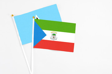 Equatorial Guinea and Saint Lucia stick flags on white background. High quality fabric, miniature national flag. Peaceful global concept.White floor for copy space.
