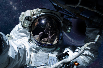 Astronaut with spaceship in a front of black hole in outer space. Global disaster avoid concept,...