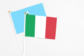 Italy and Saint Lucia stick flags on white background. High quality fabric, miniature national flag. Peaceful global concept.White floor for copy space.
