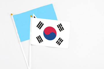 South Korea and Saint Lucia stick flags on white background. High quality fabric, miniature national flag. Peaceful global concept.White floor for copy space.
