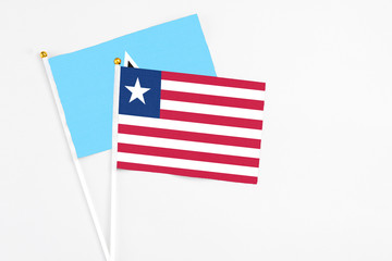 Liberia and Saint Lucia stick flags on white background. High quality fabric, miniature national flag. Peaceful global concept.White floor for copy space.