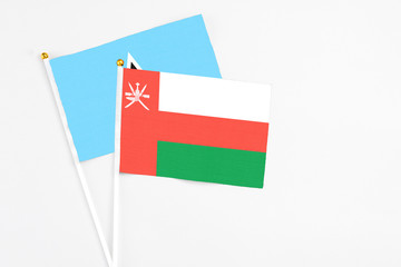 Oman and Saint Lucia stick flags on white background. High quality fabric, miniature national flag. Peaceful global concept.White floor for copy space.
