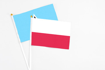 Poland and Saint Lucia stick flags on white background. High quality fabric, miniature national flag. Peaceful global concept.White floor for copy space.