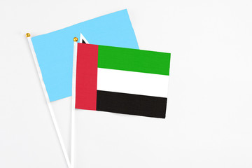 United Arab Emirates and Saint Lucia stick flags on white background. High quality fabric, miniature national flag. Peaceful global concept.White floor for copy space.