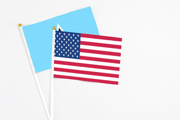 United States and Saint Lucia stick flags on white background. High quality fabric, miniature national flag. Peaceful global concept.White floor for copy space.