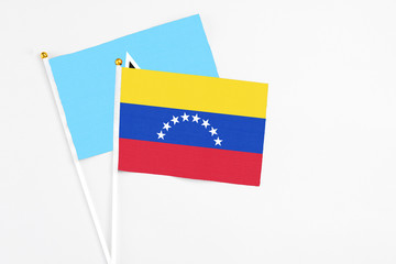 Venezuela and Saint Lucia stick flags on white background. High quality fabric, miniature national flag. Peaceful global concept.White floor for copy space.