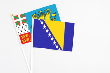 Bosnia Herzegovina and Saint Pierre And Miquelon stick flags on white background. High quality fabric, miniature national flag. Peaceful global concept.White floor for copy space.