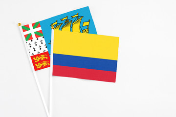 Colombia and Saint Pierre And Miquelon stick flags on white background. High quality fabric, miniature national flag. Peaceful global concept.White floor for copy space.