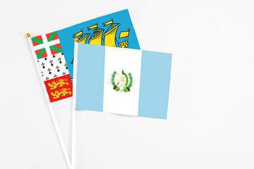 Guatemala and Saint Pierre And Miquelon stick flags on white background. High quality fabric, miniature national flag. Peaceful global concept.White floor for copy space.