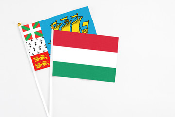 Hungary and Saint Pierre And Miquelon stick flags on white background. High quality fabric, miniature national flag. Peaceful global concept.White floor for copy space.