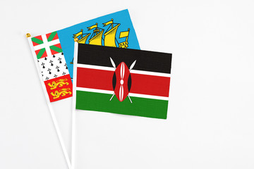 Kenya and Saint Pierre And Miquelon stick flags on white background. High quality fabric, miniature national flag. Peaceful global concept.White floor for copy space.