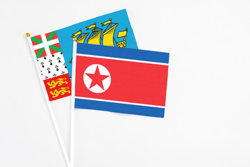 North Korea and Saint Pierre And Miquelon stick flags on white background. High quality fabric, miniature national flag. Peaceful global concept.White floor for copy space.