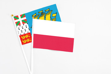 Poland and Saint Pierre And Miquelon stick flags on white background. High quality fabric, miniature national flag. Peaceful global concept.White floor for copy space.