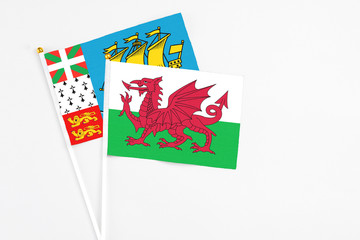 Wales and Saint Pierre And Miquelon stick flags on white background. High quality fabric, miniature national flag. Peaceful global concept.White floor for copy space.