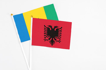 Albania and Saint Vincent And The Grenadines stick flags on white background. High quality fabric, miniature national flag. Peaceful global concept.White floor for copy space.