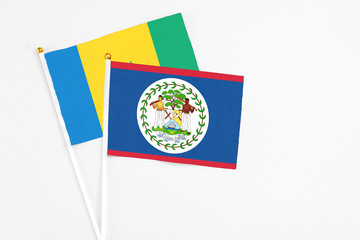 Belize and Saint Vincent And The Grenadines stick flags on white background. High quality fabric, miniature national flag. Peaceful global concept.White floor for copy space.