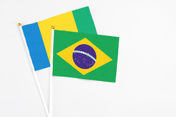 Brazil and Saint Vincent And The Grenadines stick flags on white background. High quality fabric, miniature national flag. Peaceful global concept.White floor for copy space.